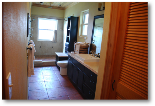 Master bathroom includes three shower heads, bath linens all overlooking the ocean